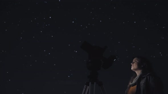 Woman photographing night sky alt