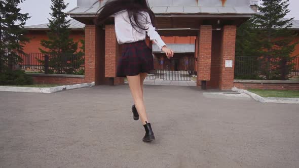 Attractive Woman Jumping To Gates and Turns Around. Lady Smiles Nicely, Happily. alt