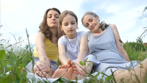 Cute Child Girl with Her Young Mother and Senior Grandmother are Having Picnic During Summer Outdoor alt
