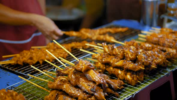 Cook Roasts Tasty Meat Kebabs on A Hot Grill at The Night Market. Traditional Street Food in Asia alt