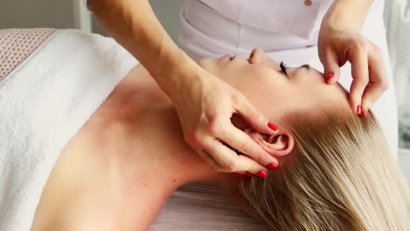 Beautician cosmetologist makes a relaxing head and hair massage professional procedure alt