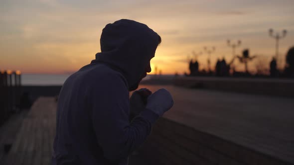 Male Boxer Is Fighting with Air Alone in Sunset Time on Open Sport Area alt