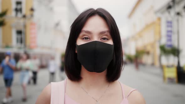 Face of a Mixed Race Woman with Dark Hair Out and About in the City Streets During the Day Wearing a alt