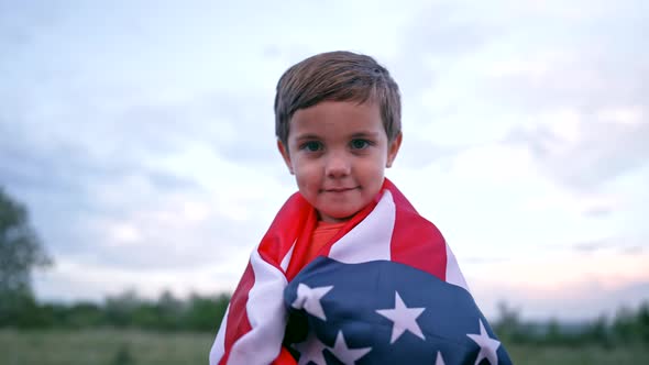 Portrait of Handsome Boy  American Patriot Child Stands with National Flag alt