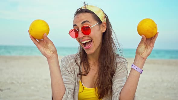 Funny Playful Young Woman Wearing Summer Clothes Holding Fruits Over Her Eyes alt