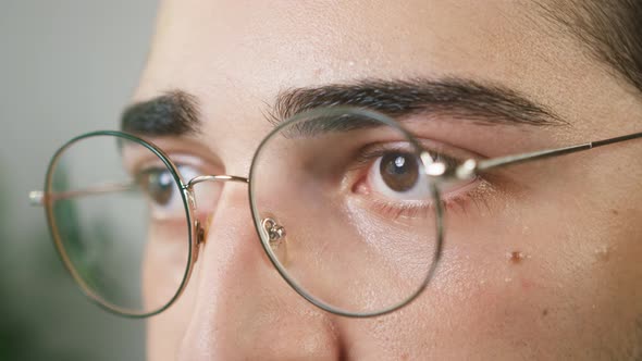 Brown Eyes of Young Brunette Man Wearing Circle Glasses Closeup Shooting Male Face with Eyewear Calm alt