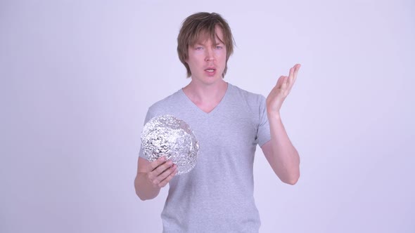 Young Man with Tinfoil Hat Talking and Explaining About Conspiracy Theory Concept alt
