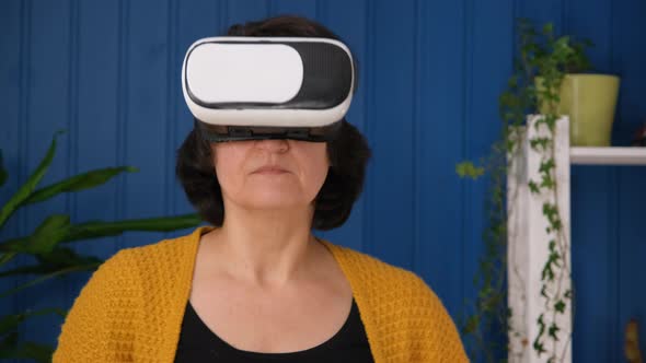 Middle Aged Woman in Living Room Playing in Modern Games Using Virtual Reality Glasses