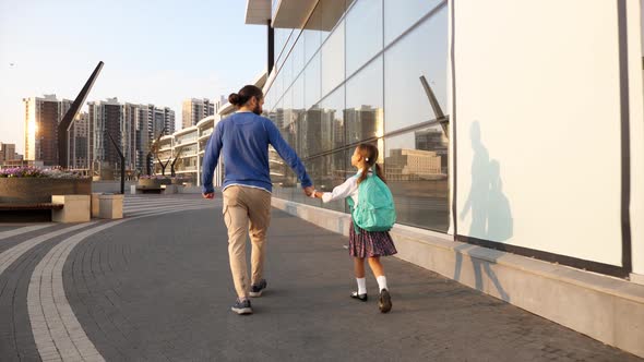 Father with Little Daughter in Uniform Going to School at Morning