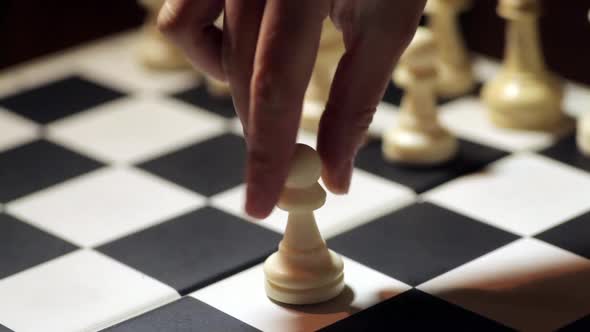 Chess board, with a hand moving the white pawn