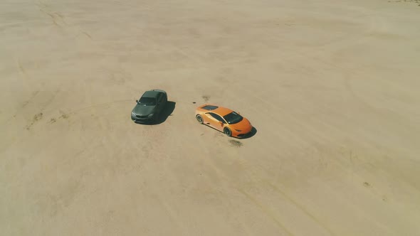 Aerial Around Modern Design Sport Cars Ready for Racing By Dusty Desert Dry Lake alt