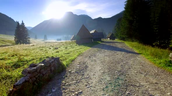 Footpath between cottages in the valley Chocholowska at sunrise, Tatra Mountains, Poland alt