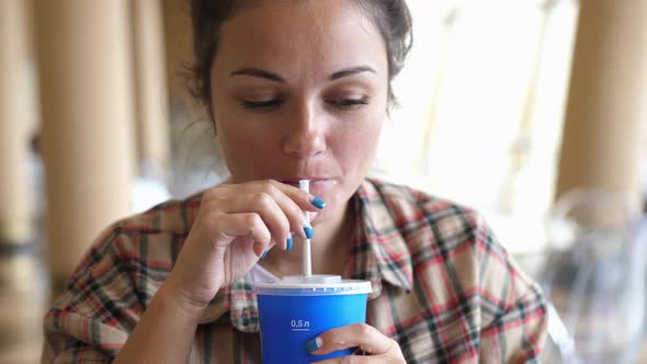 Young Woman Enjoying a Drink with the Straw