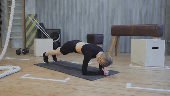Beautiful and Young Girl Does Plank on Her Fitness Mat. Athletic Woman Does Workout alt