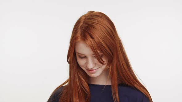 Shy Coy Ginger Caucasian Teenage Girl Standing Smiling on White Background in Slowmotion alt