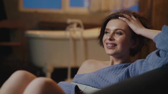 Attractive Girl in Cozy Clothes Having Fun and Using Laptop for Chatting alt