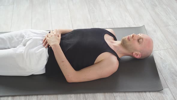 Young Man Rests on the Floor After Yoga