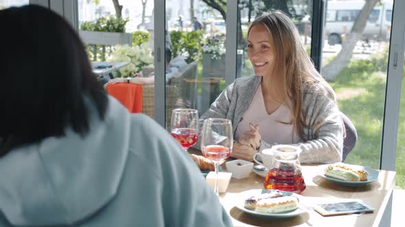 Happy Future Mother Receiving Present Baby Shoes From Caring Friends in Summer Cafe alt