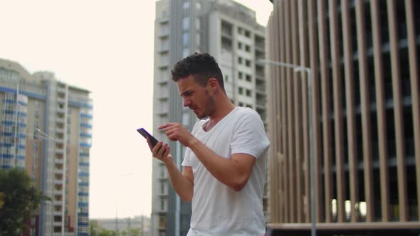 Young Handsome Man Looking for a Stable Wifi Connection in a Big City alt