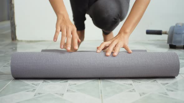 Young woman doing sports and using yoga mat for digital workout sessions at home