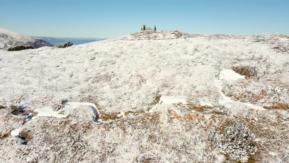 Travelers Stand on Top of a Snowy Mountain