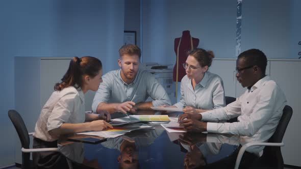 Creative Designers Discussing Color Tones at Meeting in Office alt