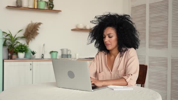 Cute African American Woman Studying Online or Remote Working Using Laptop While Taking Notes in alt