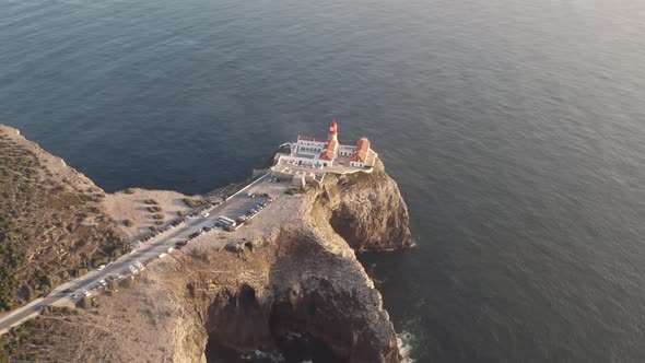 Seascape of Cabo de Sao Vicente lighthouse on top of rugged cliff surrounded by Atlantic Ocean. alt