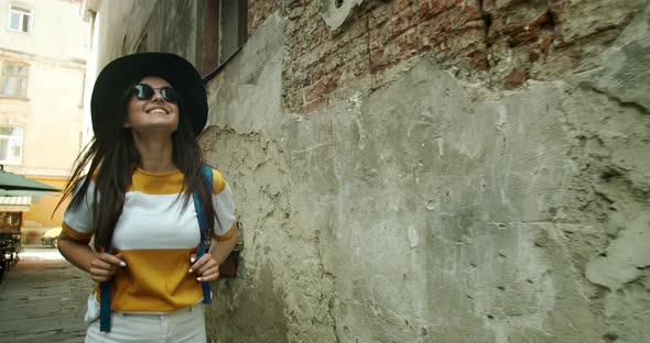 Female Tourist in Hat Walking on Street