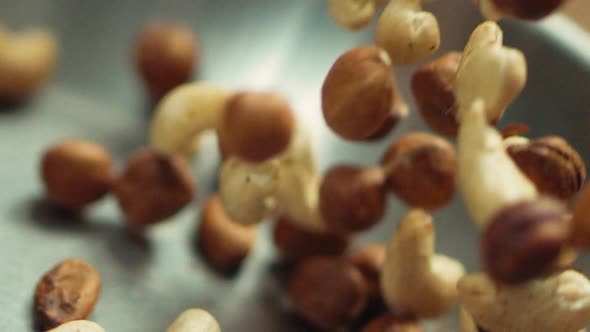 Closeup Nuts Frying on Metal Pan in Slow Motion. Mix of Hazel and Cashew Nuts alt
