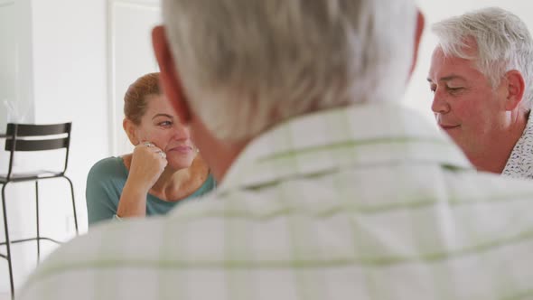 senior male and female friends sitting at a table together socialising before their ballroom dancing alt