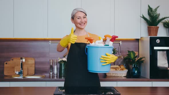 Asian Looking Woman Shows Thumb Up with Her Cleaning Bucket alt