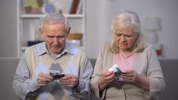 Upset Old Couple Holding Few Dollar Banknotes, Not Enough Money for Food Payment alt