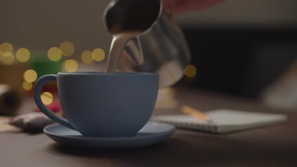 Slow Motion Orbit Shot Man Pour Hot Chocolate Blue Cup Evening Shopping List Holidays Notepad alt