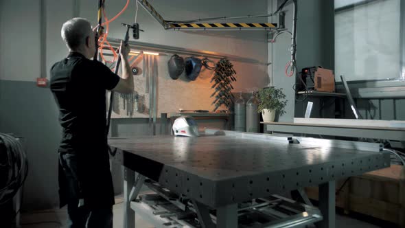 Professional welder prepares the welding equipment before starting work on metal production