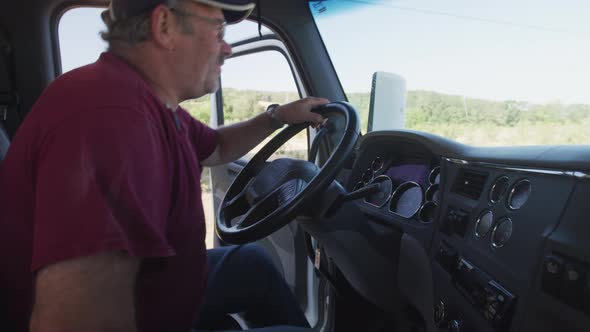 Truck driver getting in an starting up truck.  Fully released for commercial use.