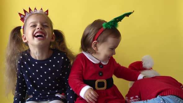 Emotion Cute Happy Siblings Friend Baby Girl Boy Fooling Around In Santa Suit Looking On Camera At