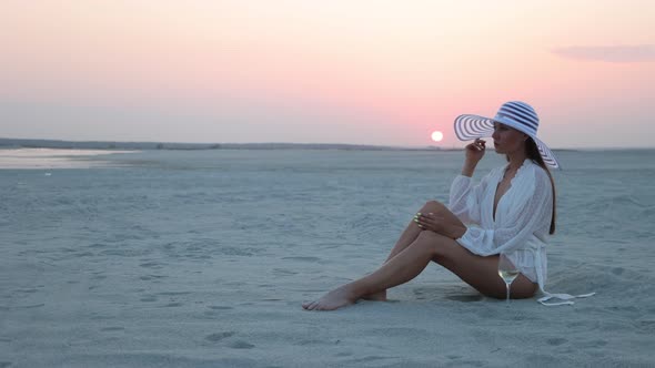 Stylish Woman in Hat Relaxing on Beach