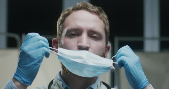 Portrait of a Handsome Doctor Removing Face Mask Close Up