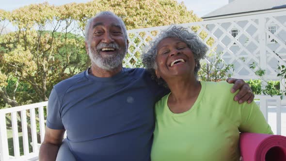 Animation of happy african american senior couple holding yoga mats on patio alt
