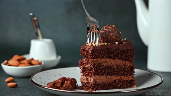 Eating chocolate cake. Taking a bite of chocolate cake with a fork. Hazelnut cake. Coffee cake