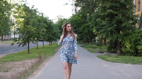 Gorgeous Woman in Dress Walking Towards Camera in the Street