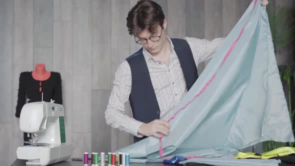 Middle Shot of Confident Professional Tailor Measuring Cloth with Tape in Atelier alt