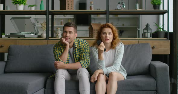 Young Couple Is Watchning TV in the Living Room alt