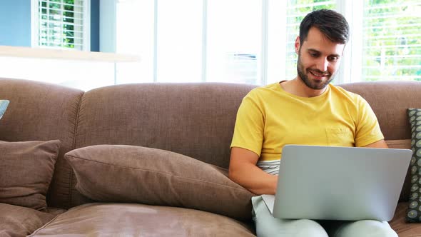Man using laptop in living room alt