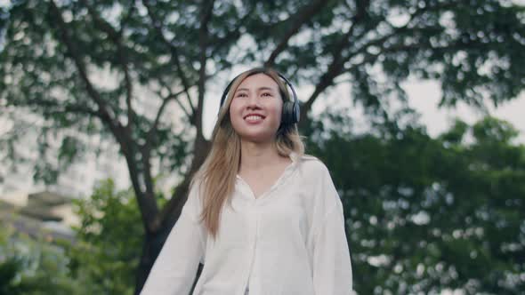 Beautiful young Asian woman enjoying the breeze outdoors.