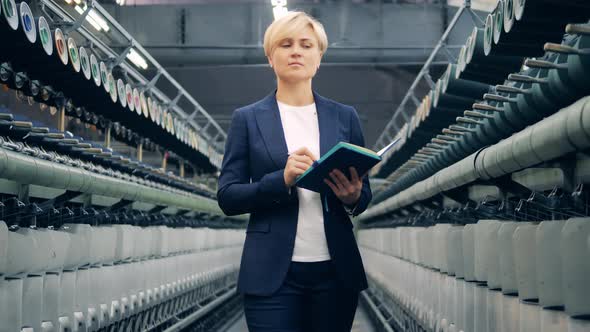 A Woman in a Business Suit is Supervising Sewing Equipment alt