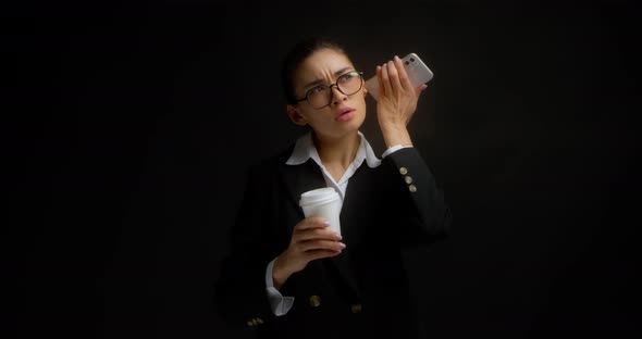 Woman Holds a Coffee in Her Hands and Listens to an Audio Message
