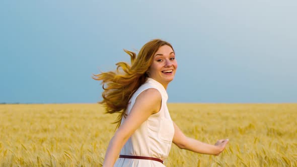 following shot of red haired woman running in wheat field in slow motion alt