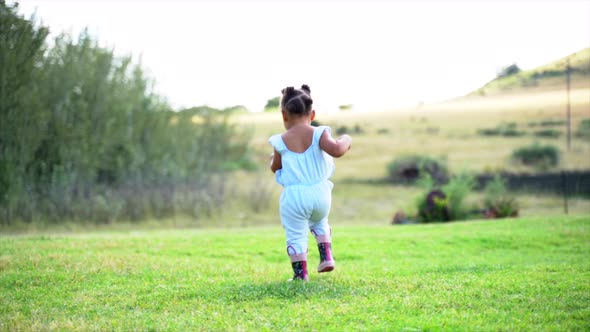 Two year old South African girl running away from camera alt